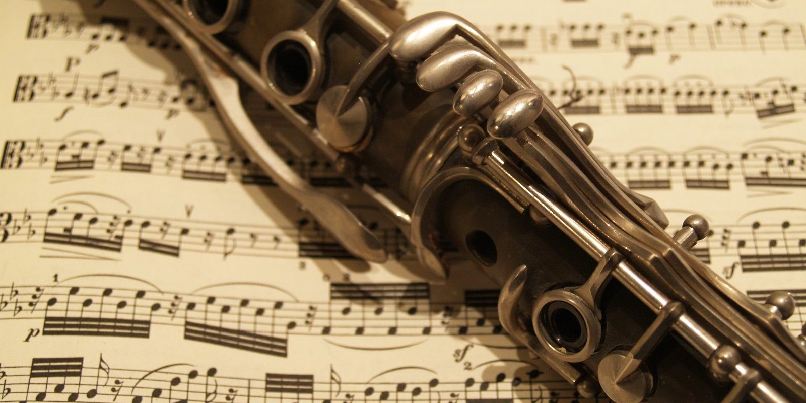 Image is of a clarinet resting on sheet music.