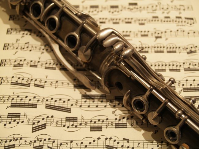 Image is of a clarinet resting on sheet music.