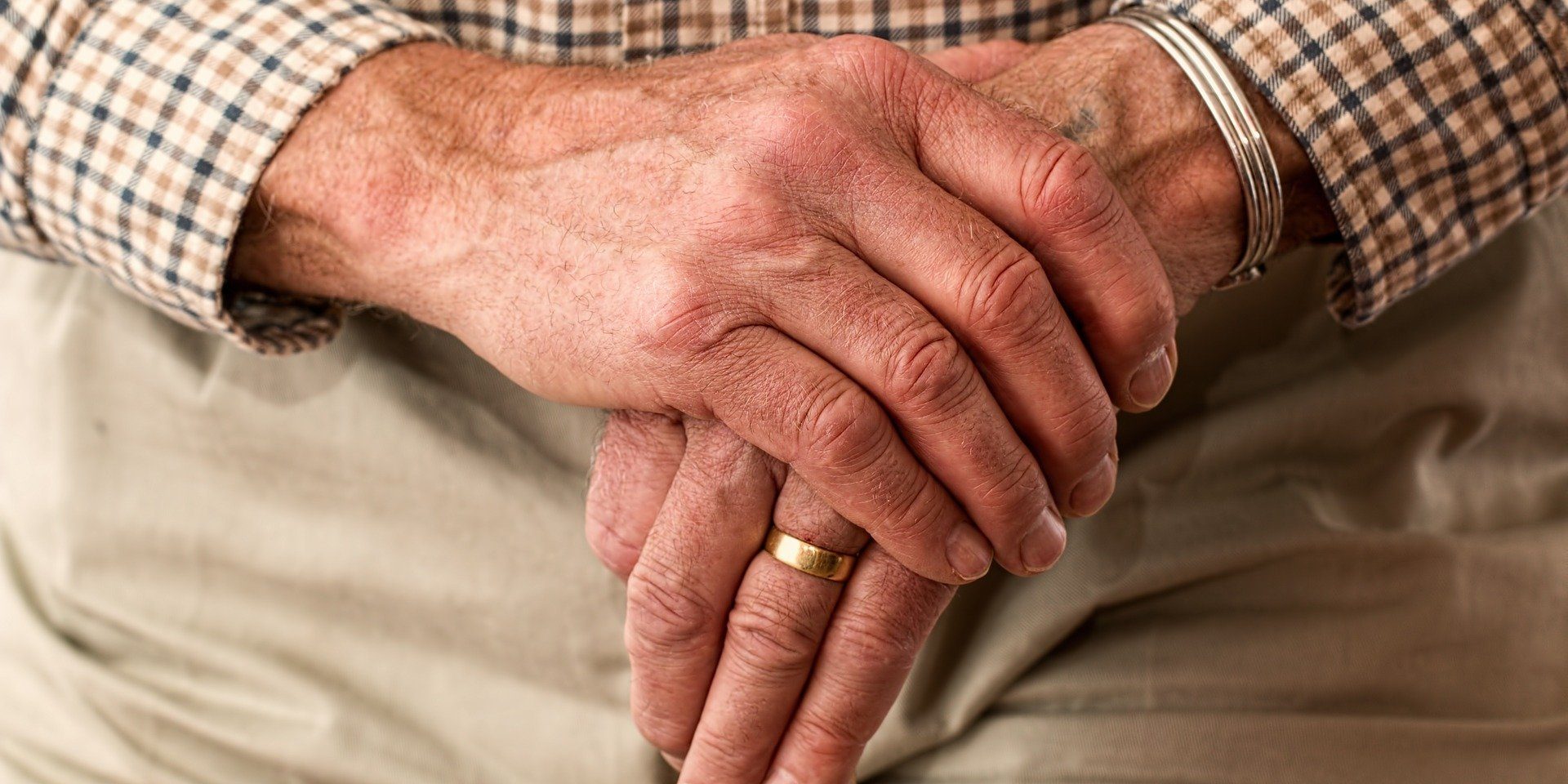 elderly hands crossed over a cane