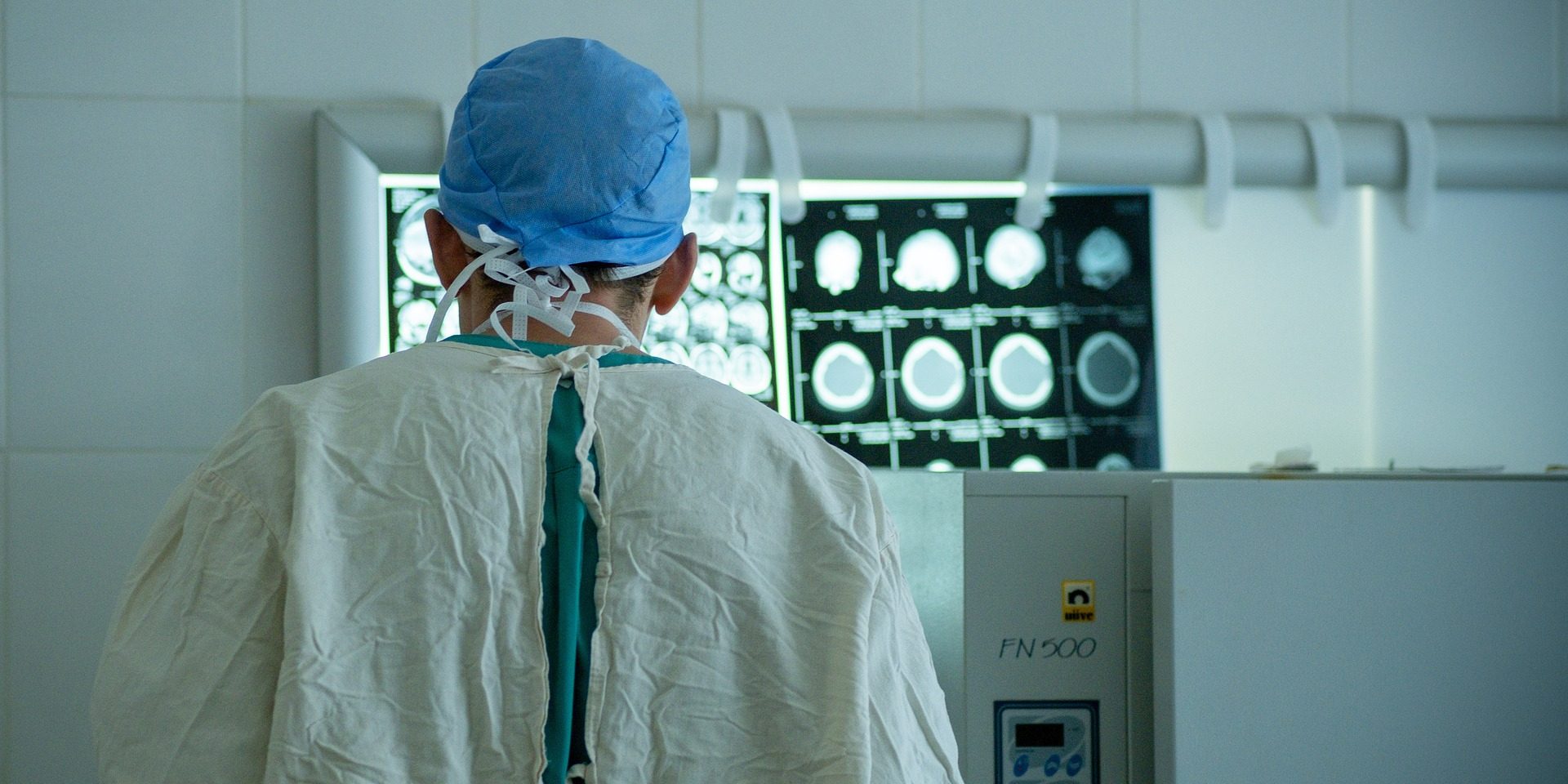 doctor 7000104 1920 scrubs looks at brain scans in hospital room.