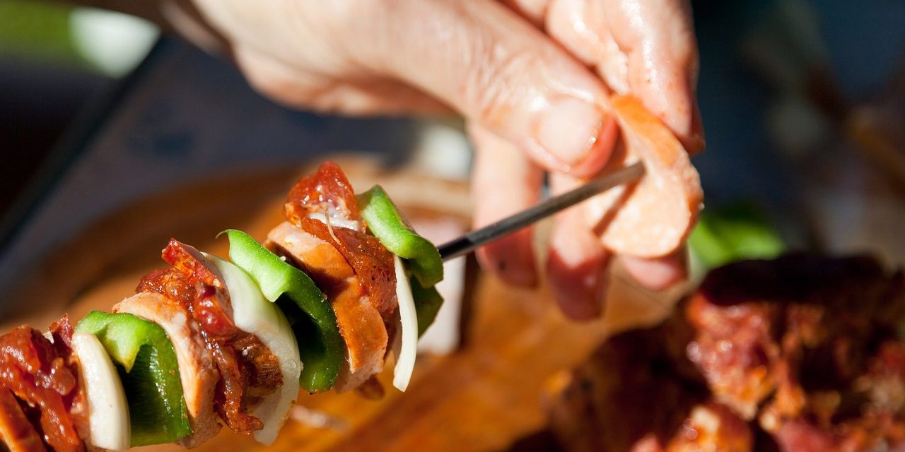 Person prepares barbecue kebab.