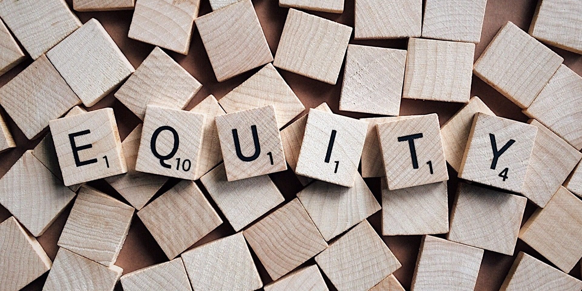 Scrabble tiles spell out "Equity."
