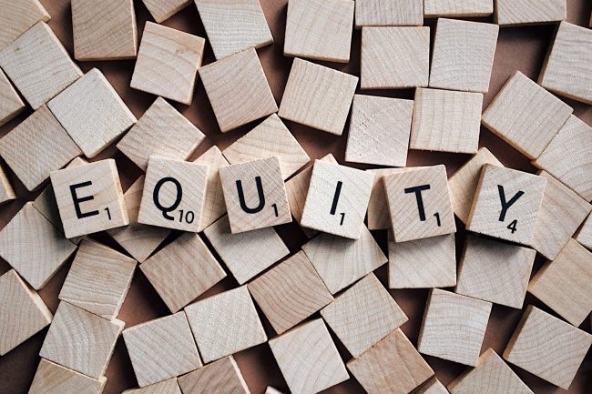 Scrabble tiles spell out "Equity."
