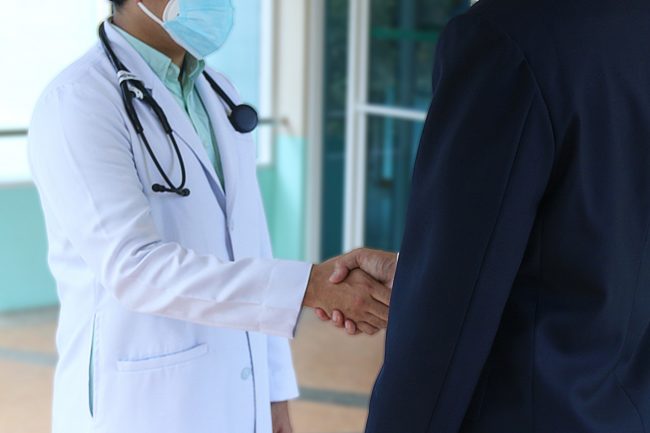 Doctor shakes hand with his patient.