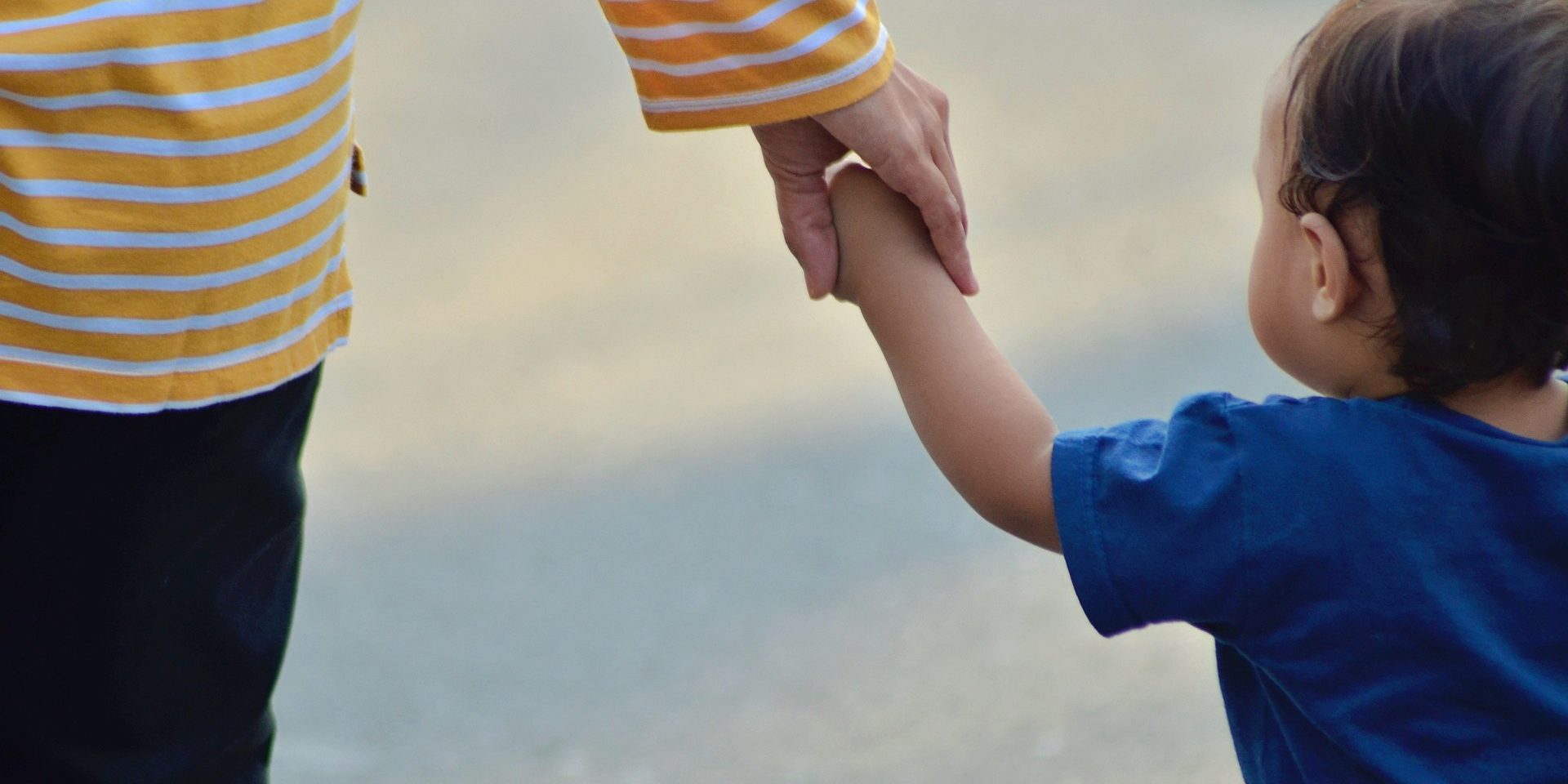 Hand clutches baby's arm.